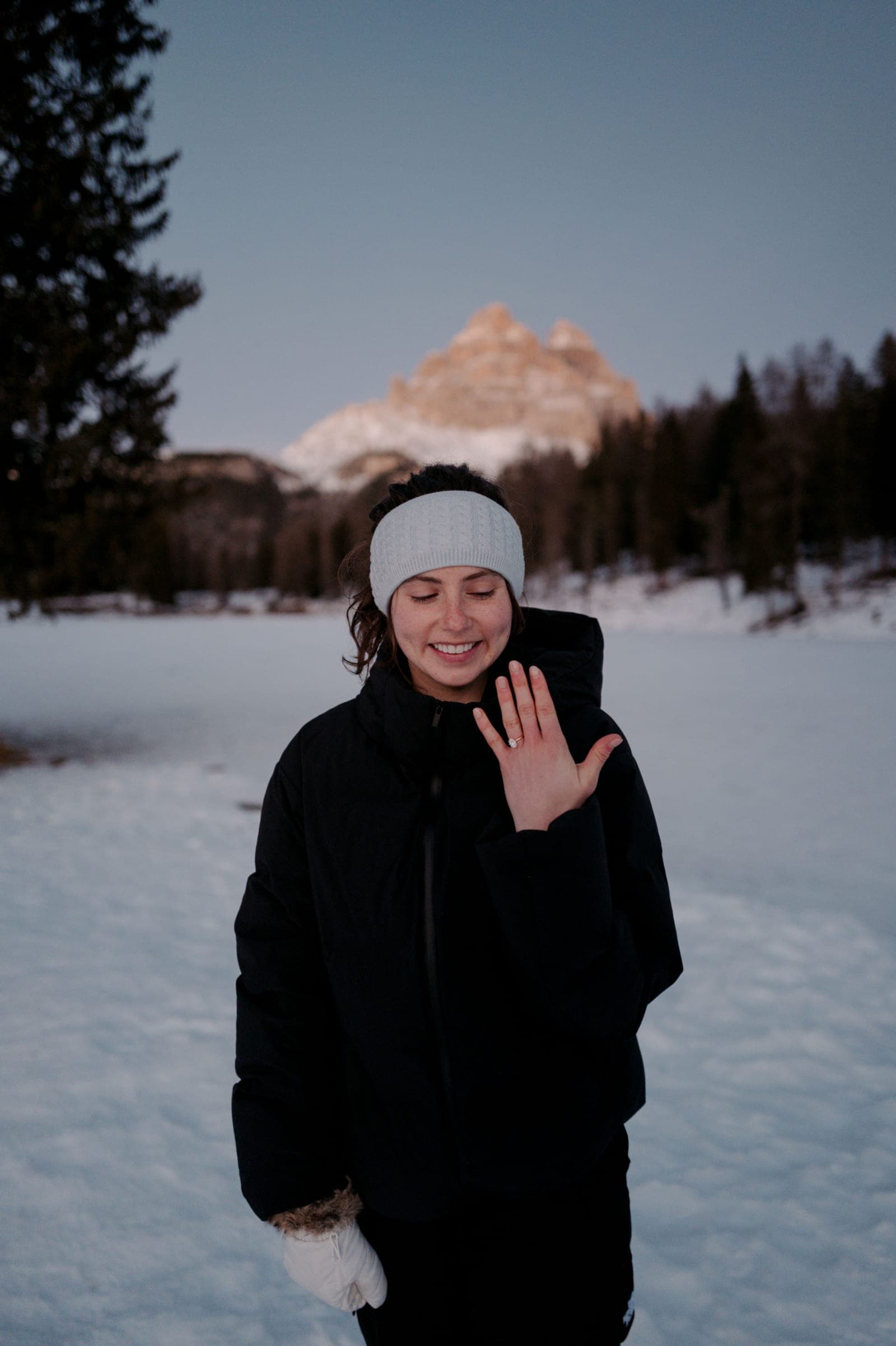 Claire showing her engagement ring in the snow beneath Tre Cime, the Dolomites, December 2025