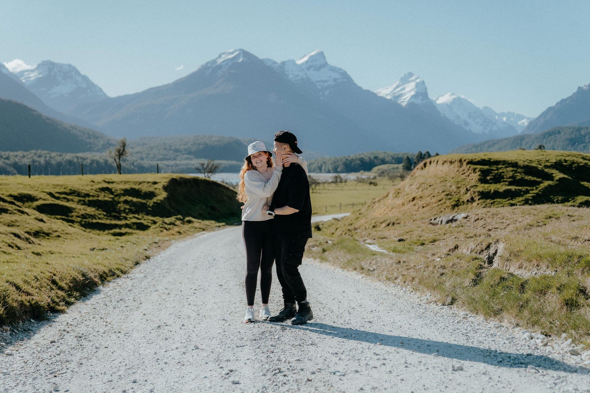 Claire and Martin on a gravel road beneath the mountains near Queenstown